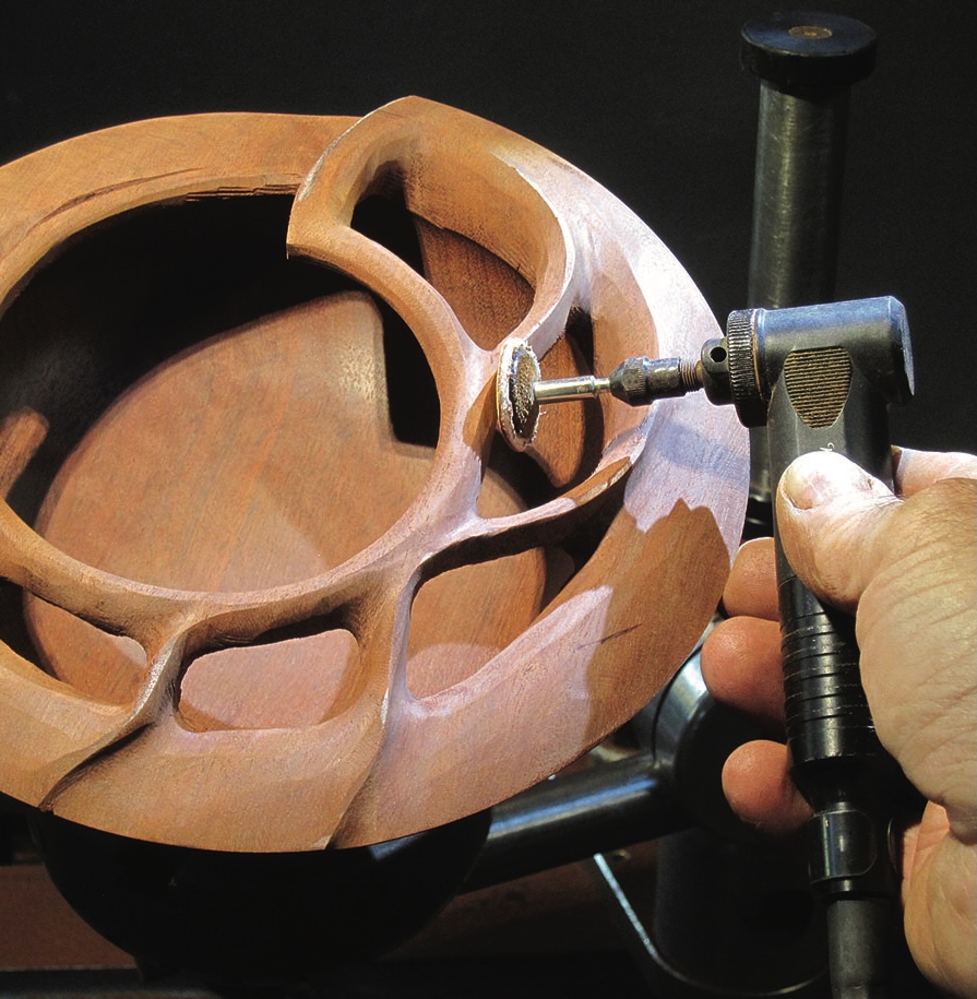 Carving a wooden bowl with rotary tool.