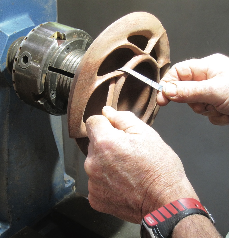 Person shaping wood on a lathe.