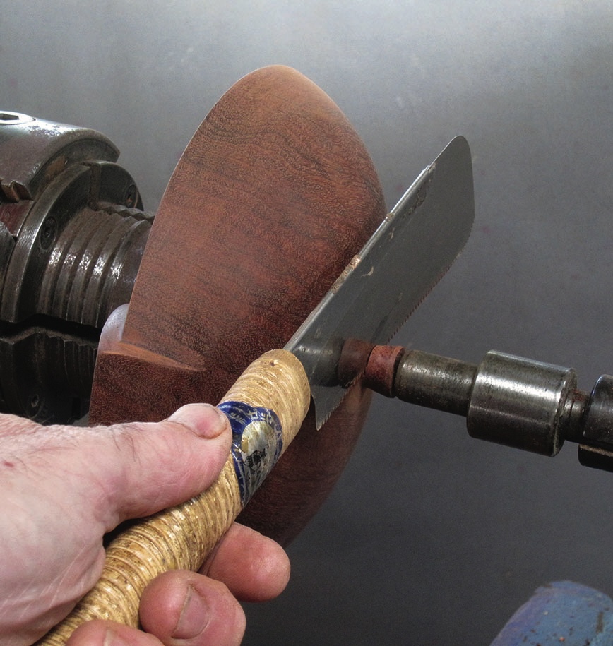 Woodturning with cutting tool on lathe machine