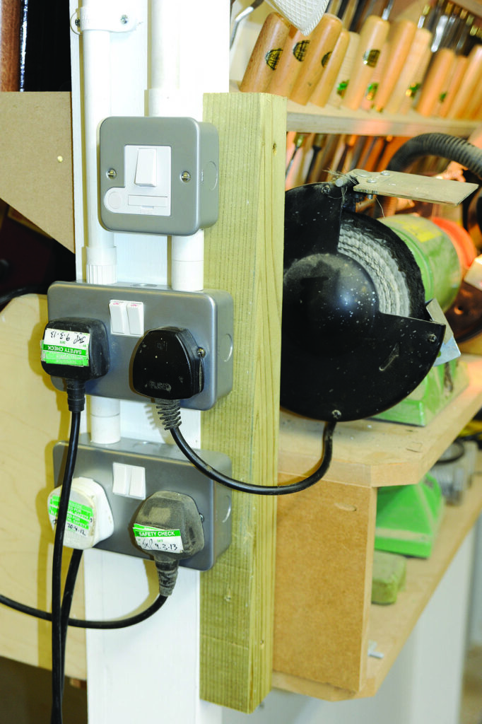 Wall-mounted electrical outlets with various plugs connected.