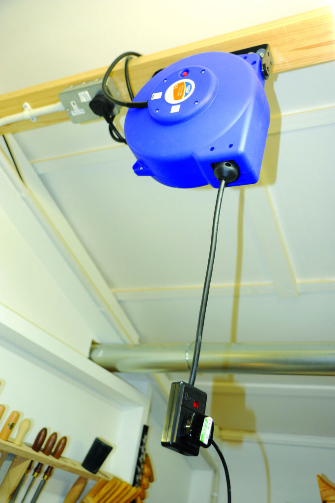 Blue retractable cable reel mounted on ceiling.