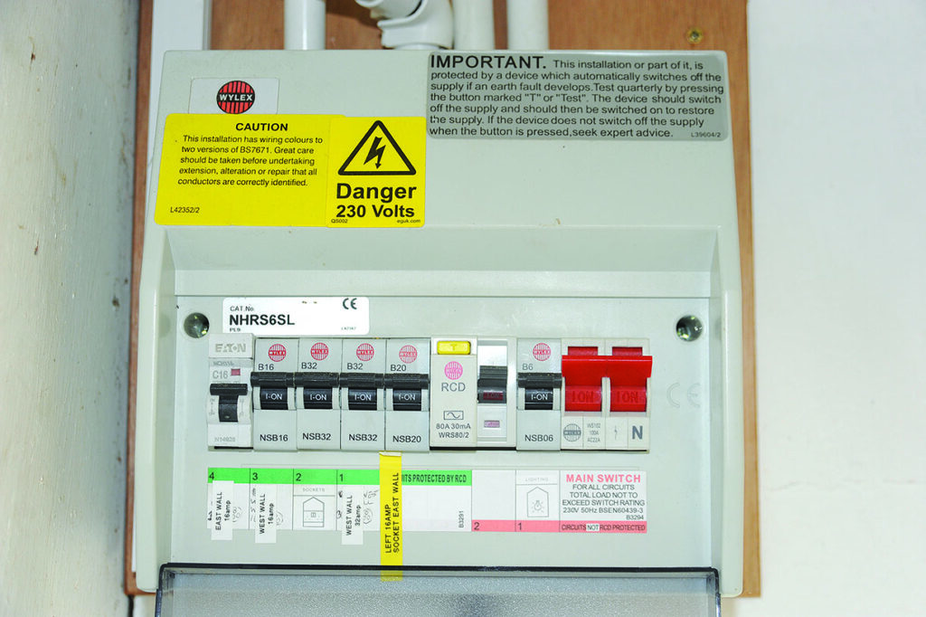 Electrical circuit breaker panel with warning labels.